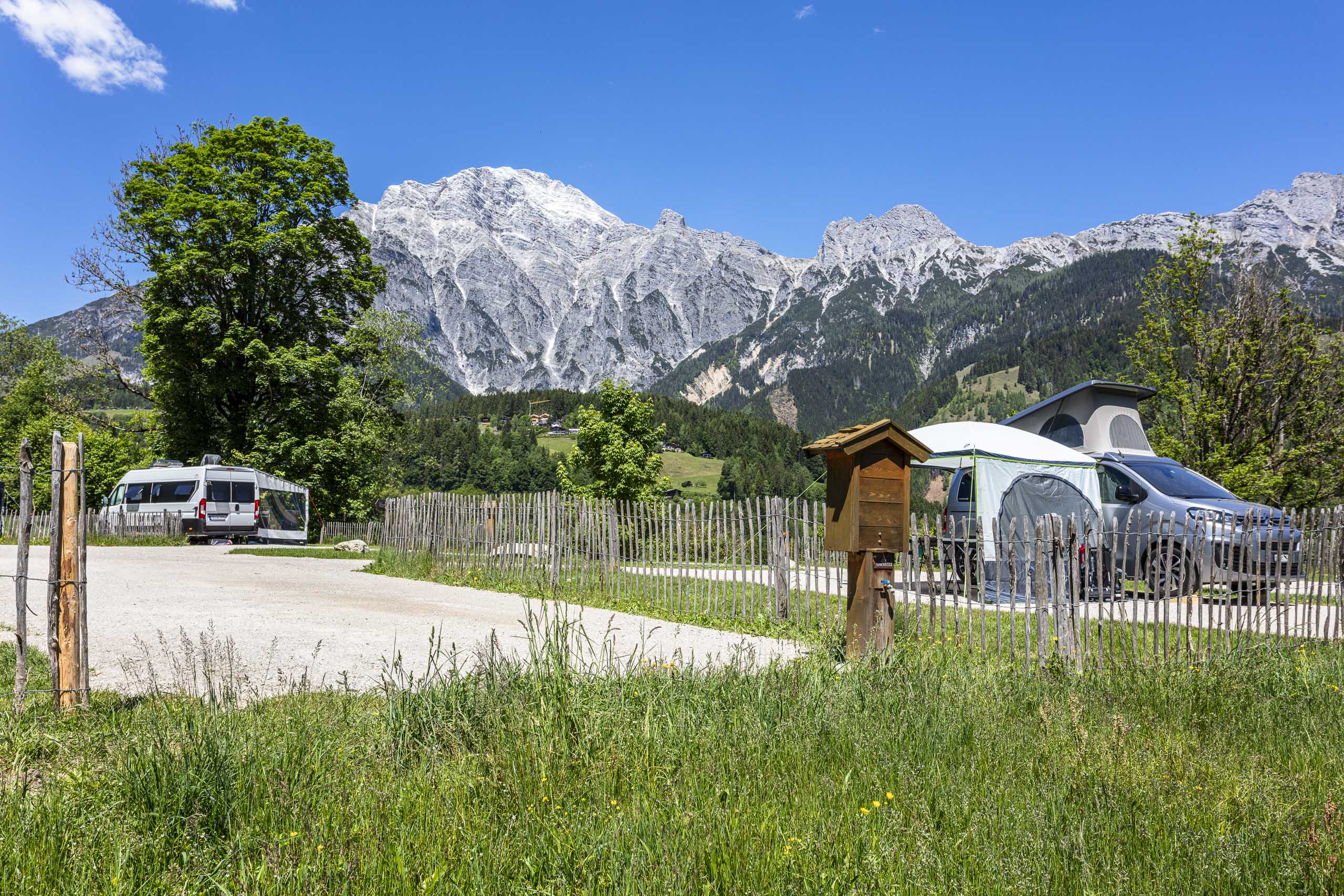 Camperplatzl Leogang mit Wohnmobilen vor den Bergen