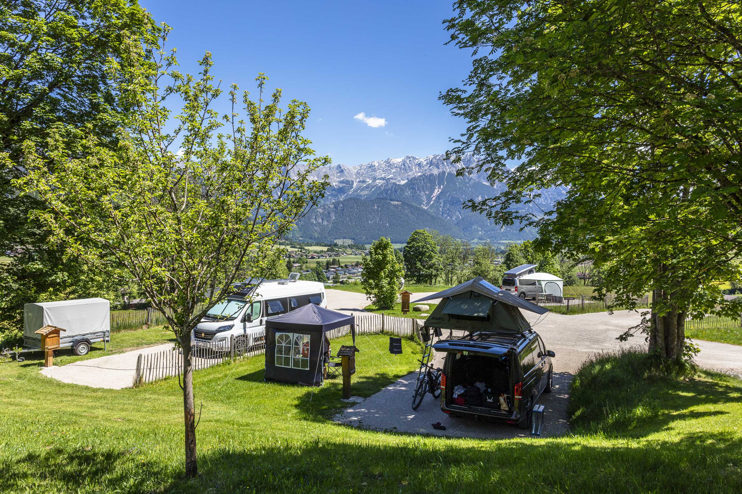 Wohnmobile auf grünen Stellplätzen am Camperplatzl Leogang