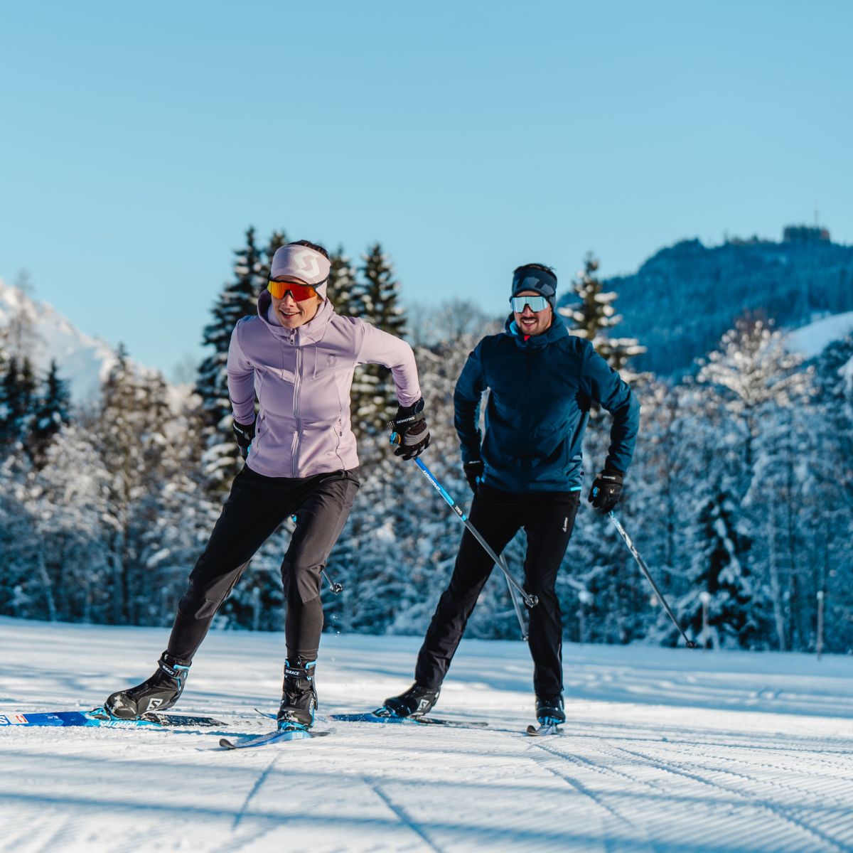 Langlaufen in der Wintersonne vor den verschneiten Bergen in Saalfelden Leogang